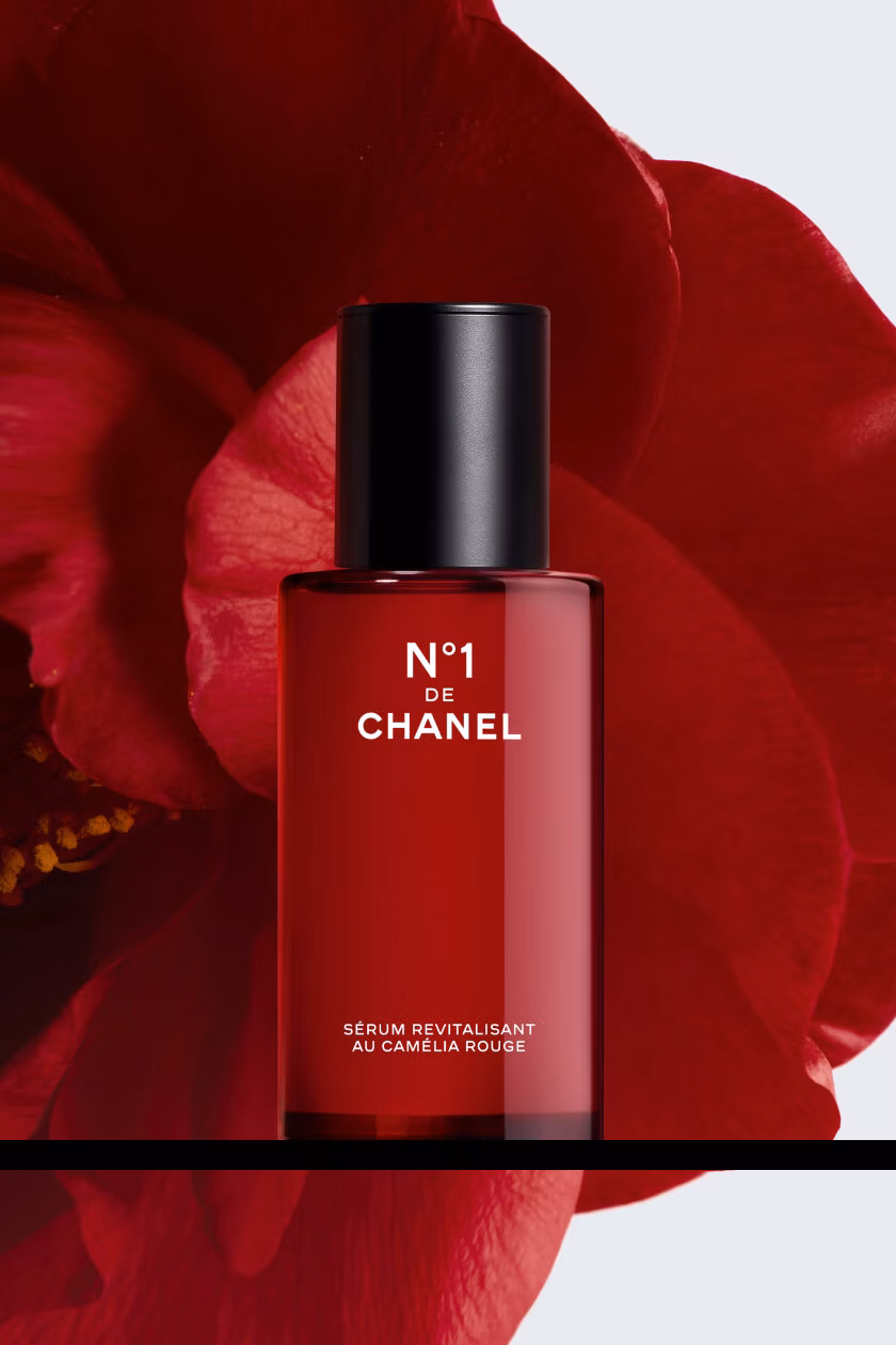 N°1 DE CHANEL Revitalizing Serum set against a red camellia.